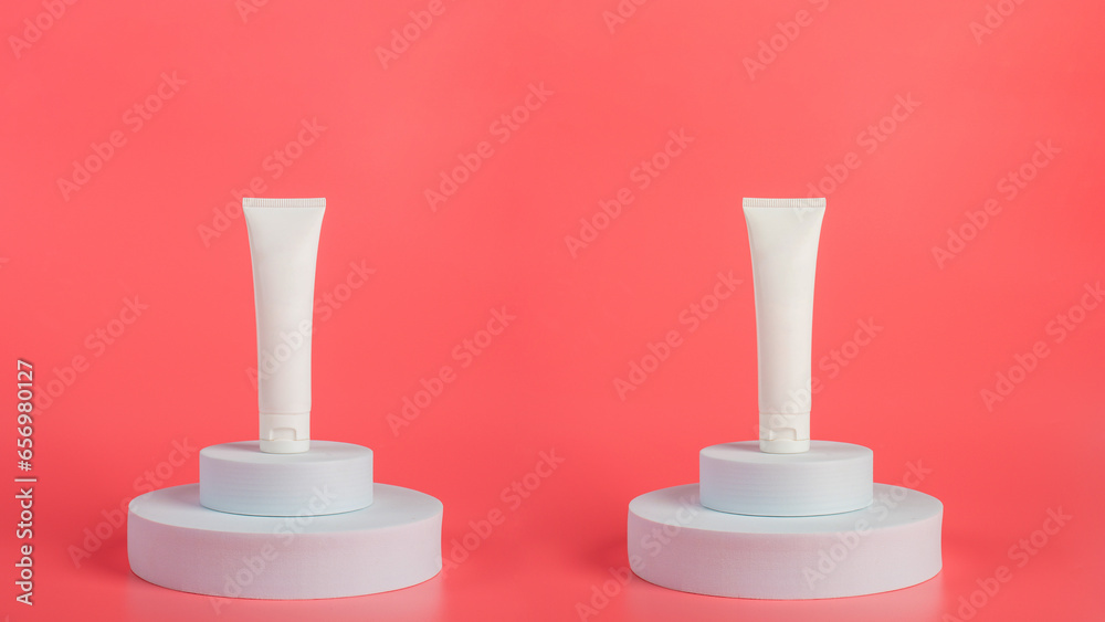 Plastic white tube for cream or lotion. Skin care or sunscreen cosmetic with stylish props on pink background Plastic white tube for cream or lotion. Skin care or sunscreen cosmetic with stylish props on pink background