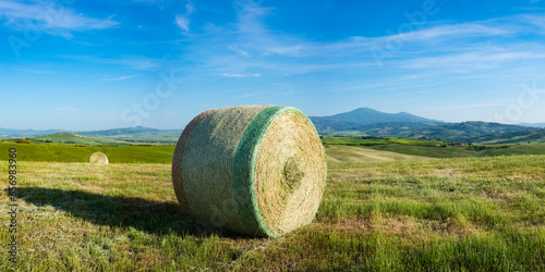 Italy, Tuscany, Pienza, Hay bale drying in summer field photo