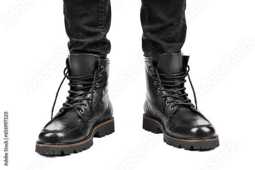 Pair of black leather boots, dress boots for men, men ankle high boots. Black brogue boots on a white background. Men fashion in leather boots. Man's legs in black jeans and brown leather boots.