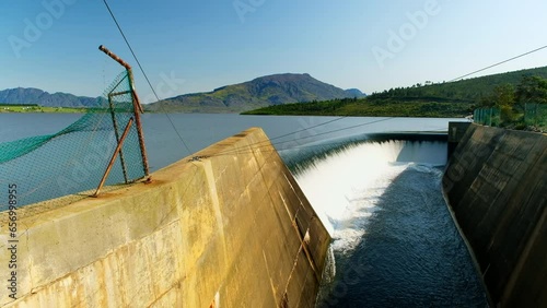 Theewaterskloof dam filled to capacity with water overflowing at spillway photo