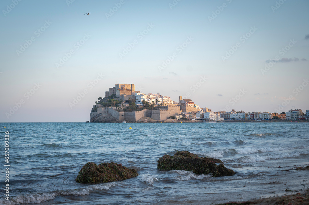 Sunset in Peñíscola, Spain, with a view of the old town, wall and castle on the Mediterranean Sea.