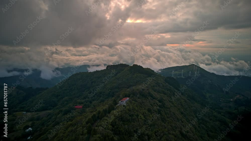 Clouds moving fast over a green hill dense vegetation wind turbine costa rica Clouds moving fast over a green hill dense vegetation wind turbine costa rica