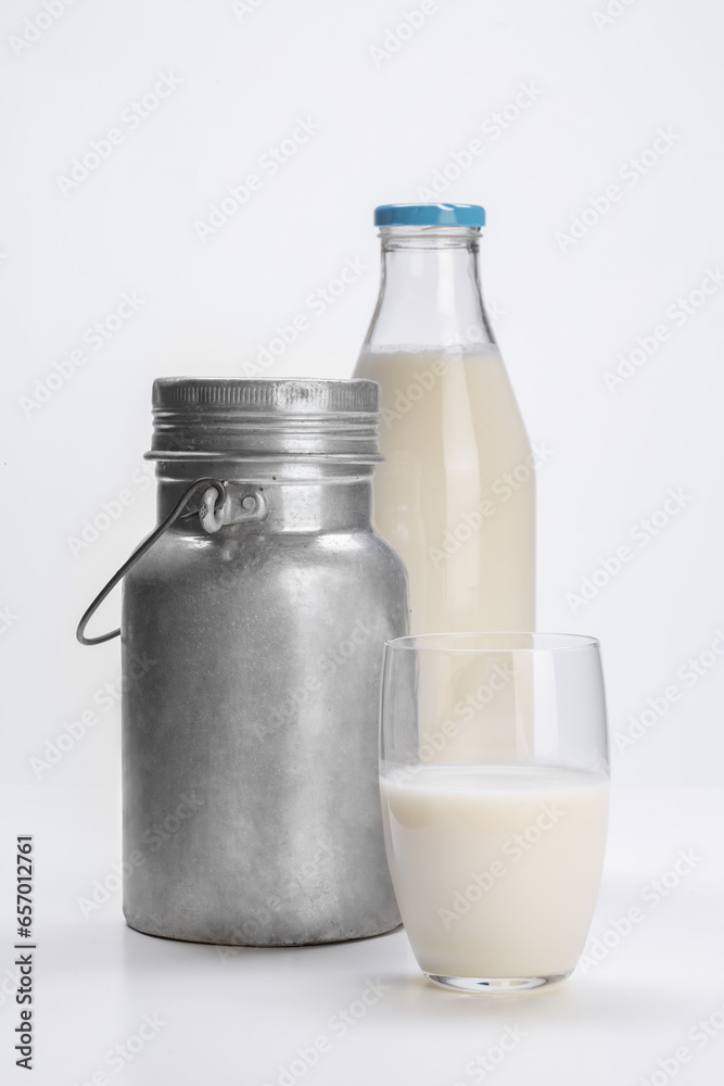 fresh milk in glass bottle with aluminum can and glass cup on white background fresh milk in glass bottle with aluminum can and glass cup on white background
