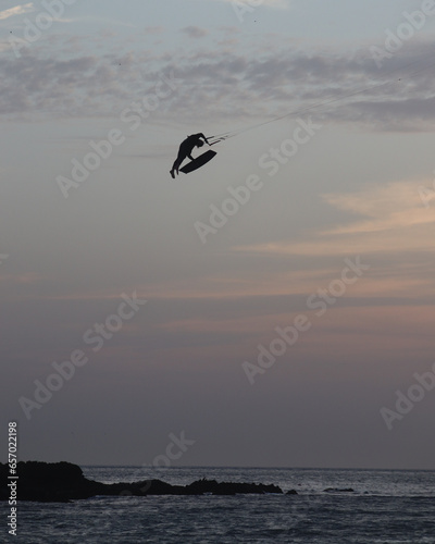 A kitesurfer in a middle of a huge jump