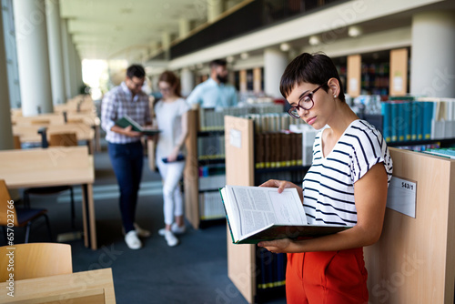 Happy group of students studying and working together in a college library