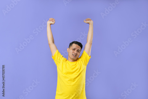 A young Asian man stretching his hands after work and feeling tired