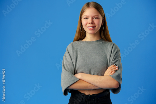 Happy teenager, positive smiling girl on blue background in studio photo