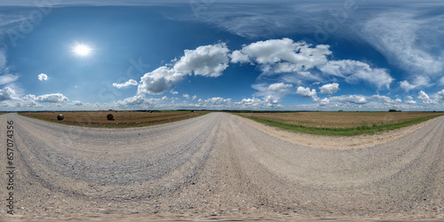 360 hdri panorama on gravel road with marks from car or tractor tires with clouds on blue sky in equirectangular spherical  seamless projection, skydome replacement in drone panoramas photo