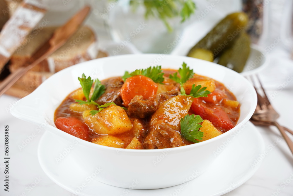 Traditional homemade Hungarian beef meat stew and soup  - Goulash with potatoes, carrots , tomatoes, bell pepper