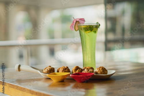 Vegetable fried momo with sauce served and Green apple mojitho mocktail over a rustic wooden background