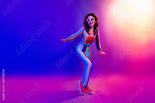 Full size portrait of positive gorgeous girl enjoy new year event dancing isolated on multicolor neon background
