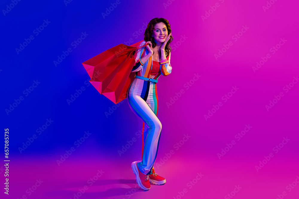 Φωτογραφία Full size photo of pretty cheerful girl wear striped costume hold mall bags isol