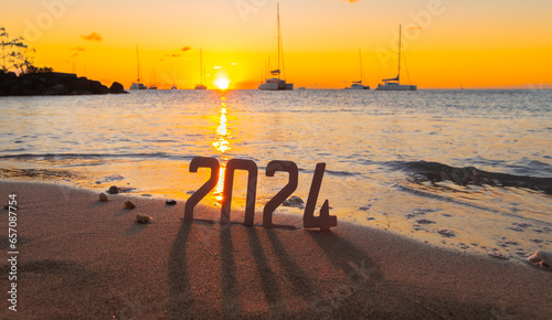 Bonne année 2024 : Concept de nouvelle année 2024 avec un lever de soleil sur une plage des Caraïbes et les chiffres 2024. 