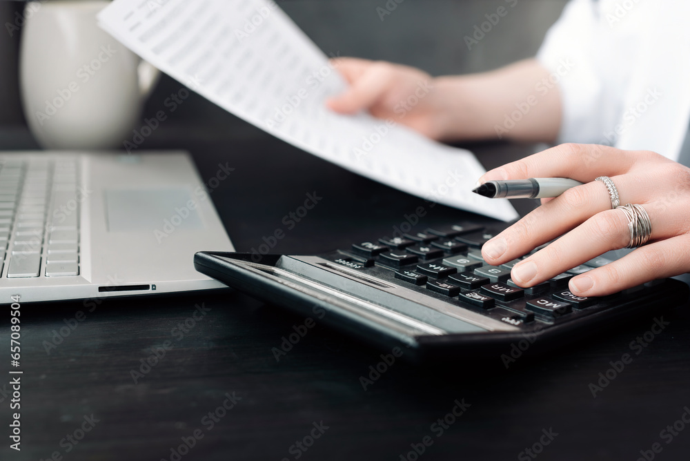 Focused Businesswoman Analyzing Financial Budget: Accounting, Finance Report, Calculator, and Document Close-Up. Financial Expertise. Businesswoman Holding Document, Using Calculator. Focused Businesswoman Analyzing Financial Budget: Accounting, Finance Report, Calculator, and Document Close-Up. Financial Expertise. Businesswoman Holding Document, Using Calculator.