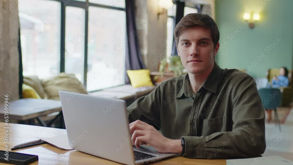 Young man typing on laptop at coworking space Young man typing on laptop at coworking space