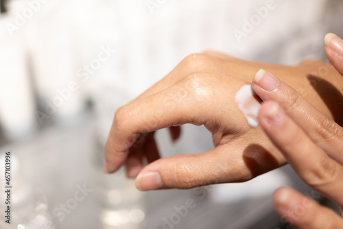 Woman testing and applying moisturizer lotion in her hand. product testing  care cosmetics. Healthy skin care.