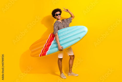 Full size photo of funny person wear leopard shirt show v-sign hold surfboard ready to catch waves isolated on yellow color background © deagreez