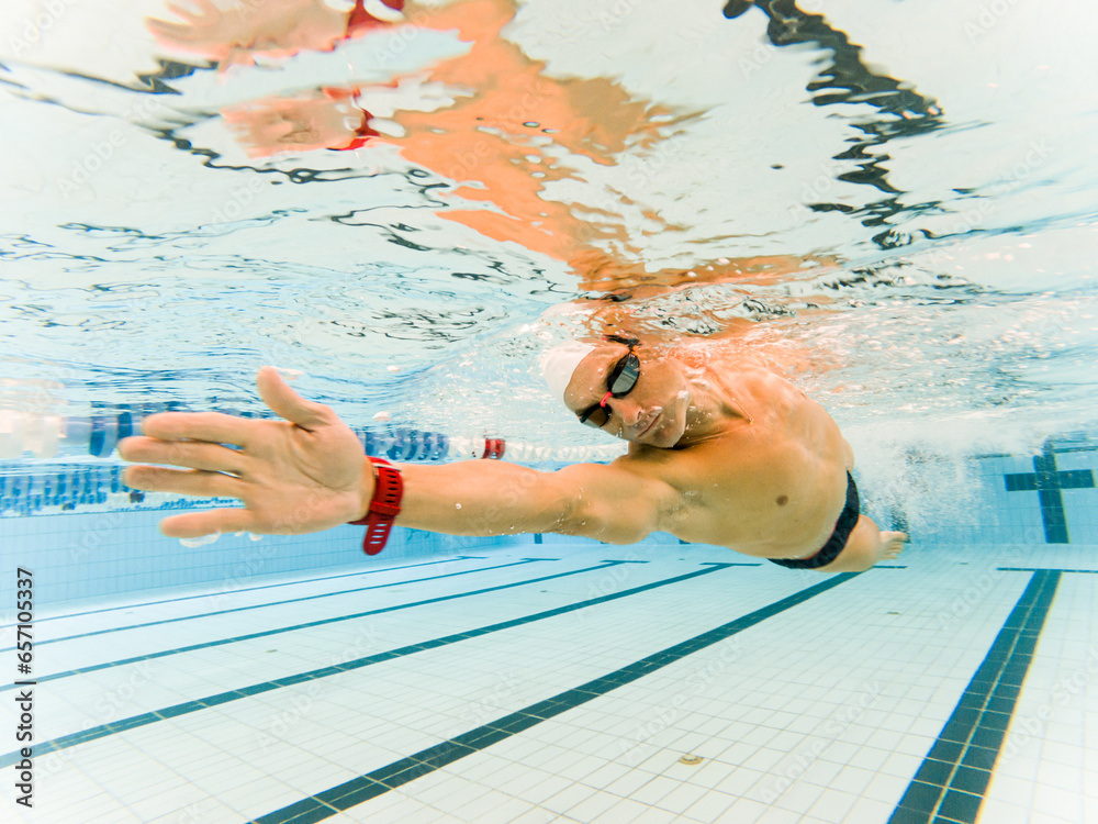Photo of an adult man with an amputated arm swimming underwater in an ...