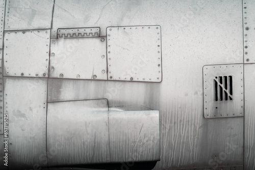 Metal skin of military fighter retro aircraft detail, surface with rivets and serrations, close-up