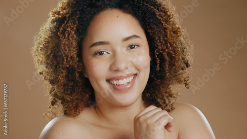 Face of happy woman, natural beauty dermatology and cosmetic wellness in studio with smile. Skin glow, portrait or confident biracial female model with skincare results or pride on brown background