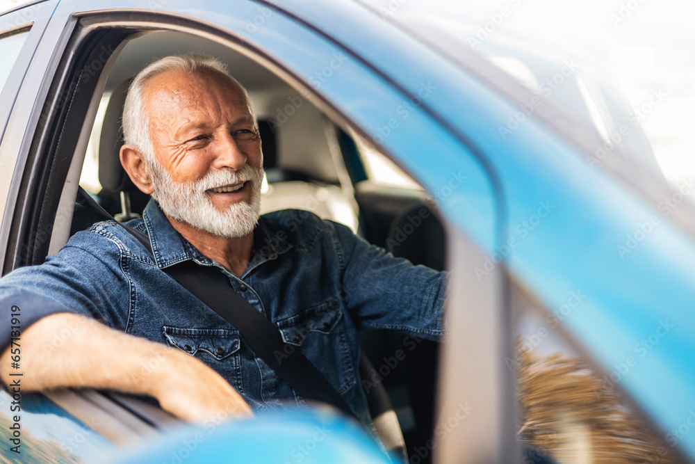 Smiling senior man driving a car and looking away. Happy senior man sitting in car in driver seat. Smiling senior man driving a car and looking away. Happy senior man sitting in car in driver seat.