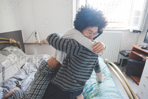 Young multiethnic couple hugging lying bed at home