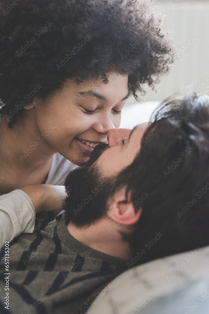 Young multiethnic couple hugging bedroom wearing pajamas Young multiethnic couple hugging bedroom wearing pajamas