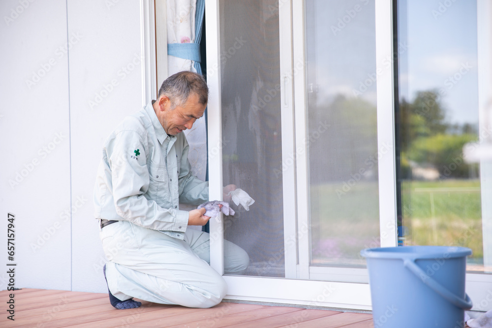 作業着で窓拭きをする男性　window cleaning