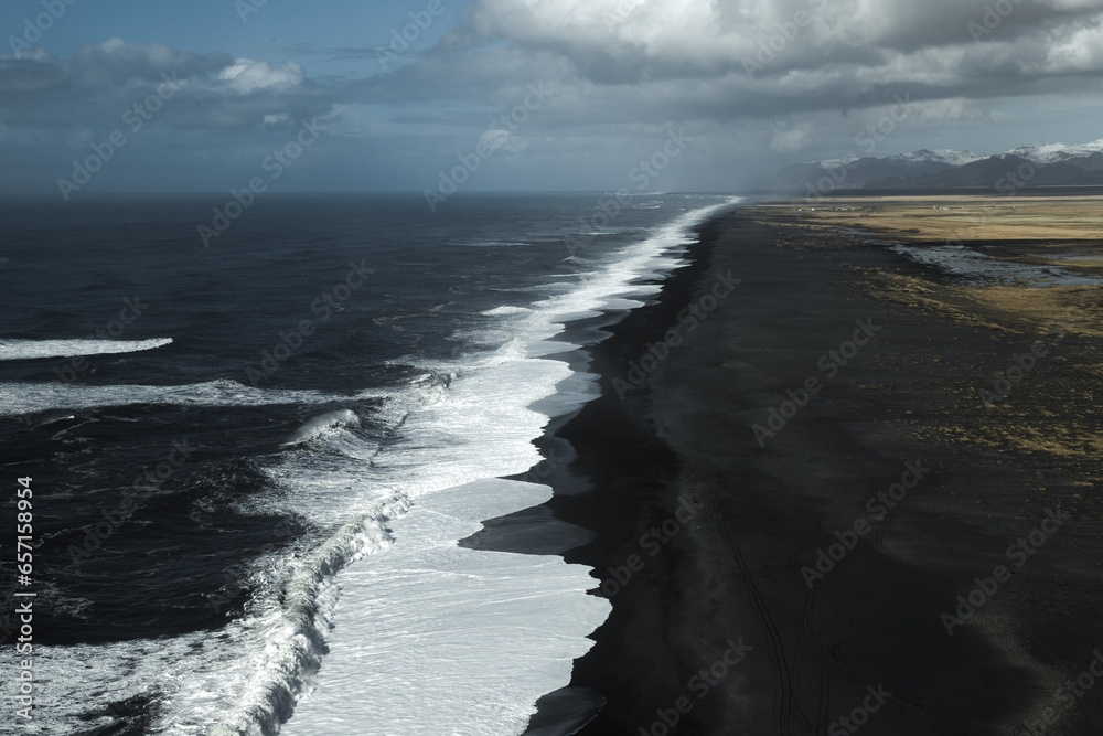 Playa infinita de arena negra con olas blancas en Islandia. Imagen de alta resolución para fondos de naturaleza salvaje. 