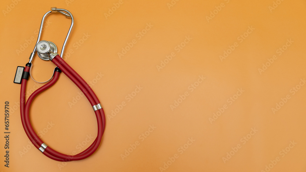 red phonendoscope on an orange background and a place for text red phonendoscope on an orange background and a place for text