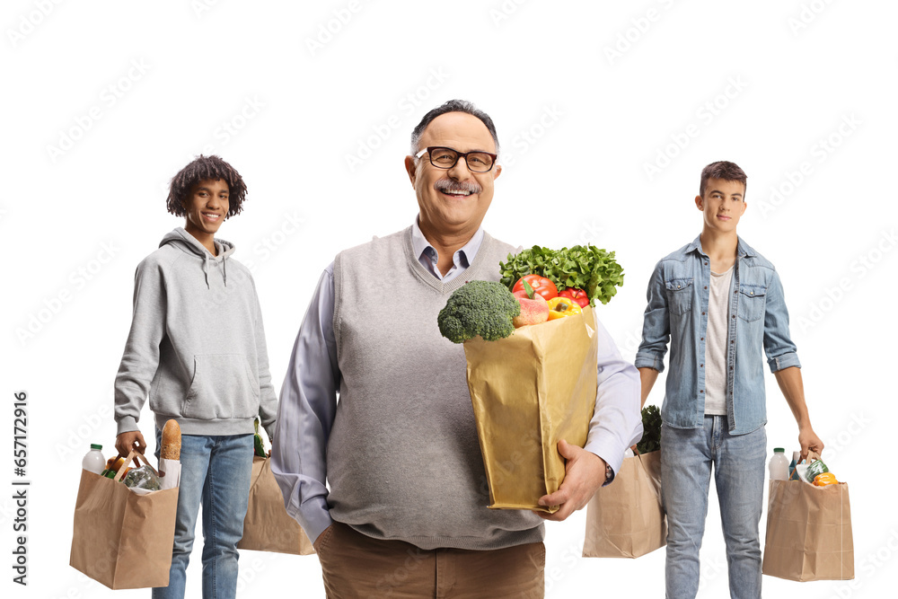 © Ljupco Smokovski - Smiling mature man standing in front of young men with grocery bags