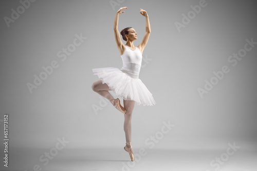 Fototapeta Naklejka Na Ścianę i Meble -  Full length shot of a ballerina in a white dress dancing