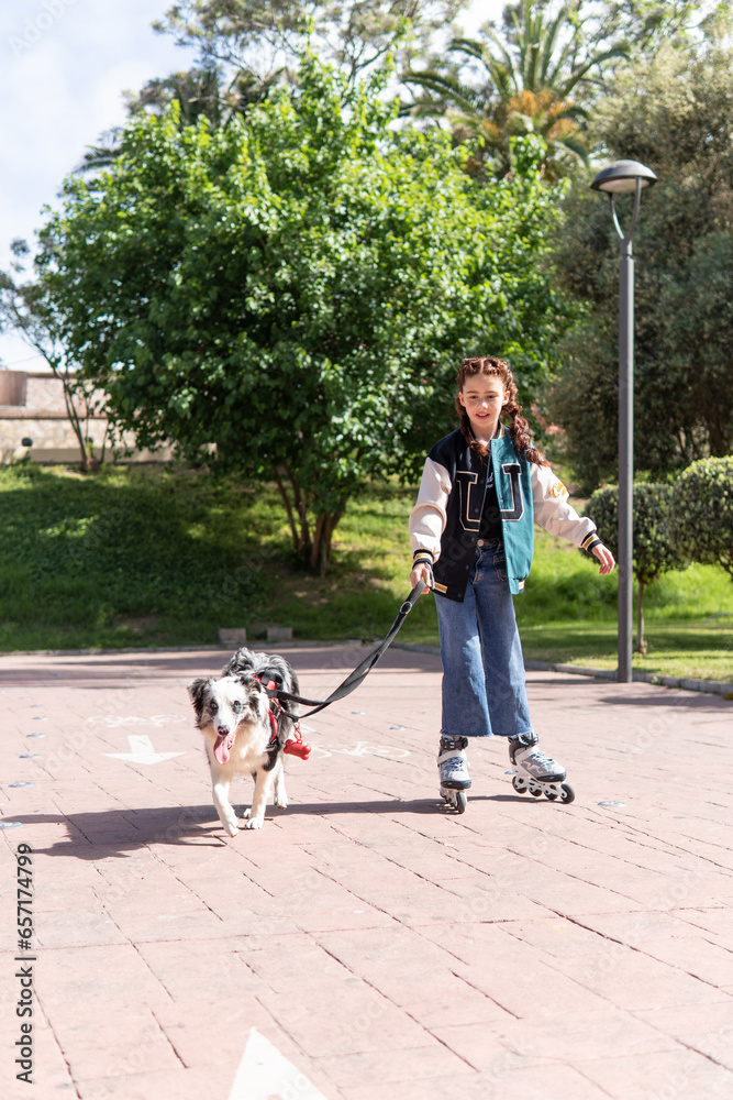 Vertical shot of a red haired girl on inline skates, enjoying with her dog in a public park. Wellness, youth and pets concepts Vertical shot of a red haired girl on inline skates, enjoying with her dog in a public park. Wellness, youth and pets concepts