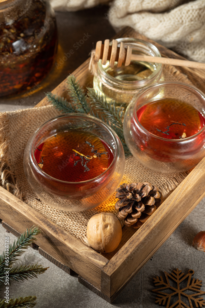 Two thermal glasses with tea or other hot drink on a wooden tray. Close-up, New Year's, winter decor. New Year cards Two thermal glasses with tea or other hot drink on a wooden tray. Close-up, New Year's, winter decor. New Year cards