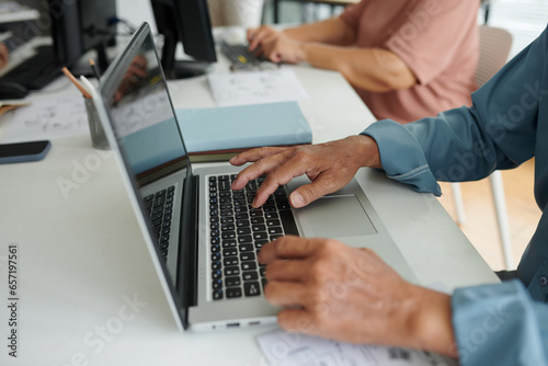 Closeup image of senior man typing on laptop when attending computer class
