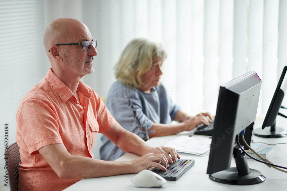 Mature man attending computer class for advanced users Mature man attending computer class for advanced users