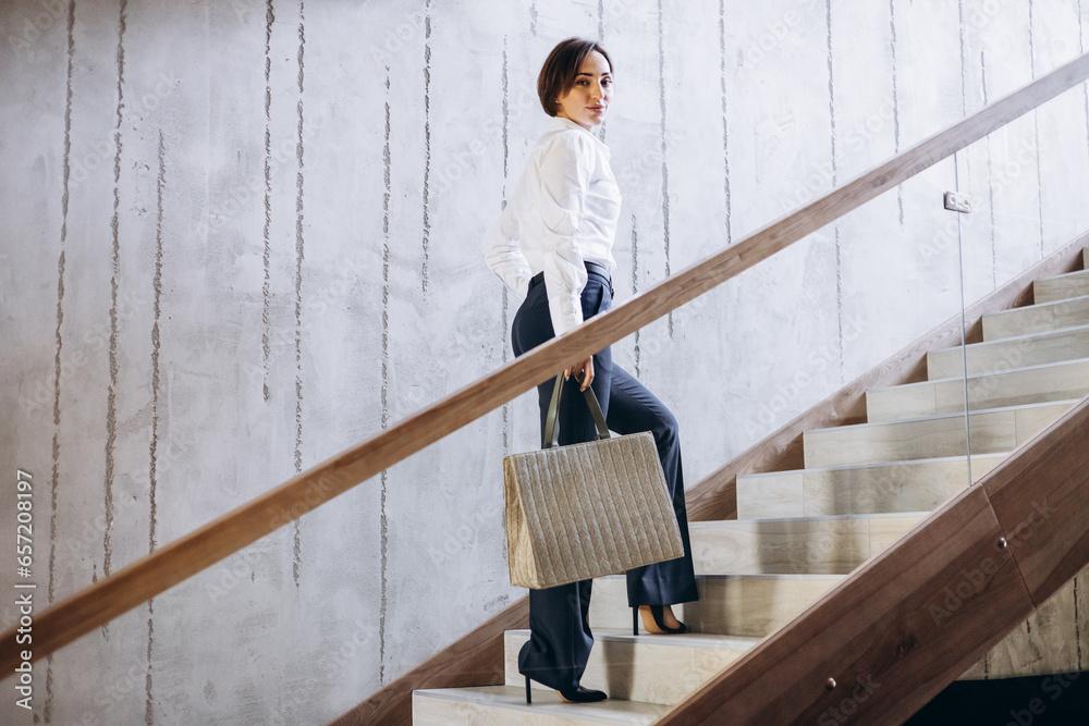 Business woman walking the hotel stairs to her room Business woman walking the hotel stairs to her room