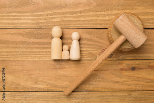 Wooden family figures with judge's gavel on wooden background,top view
