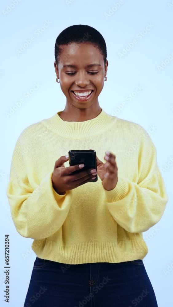 Typing, smile and black woman with phone in studio for conversation, online chat and social media. Communication, network and person on smartphone for contact, text and connection on blue background Typing, smile and black woman with phone in studio for conversation, online chat and social media. Communication, network and person on smartphone for contact, text and connection on blue background