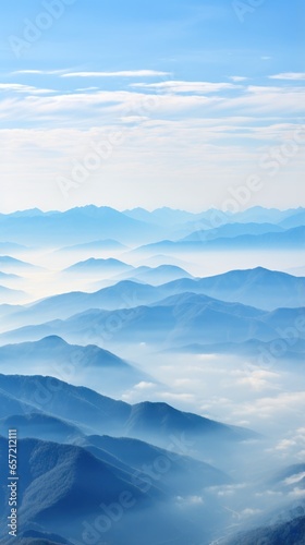 Hazy mountains seen through wispy clouds © olegganko