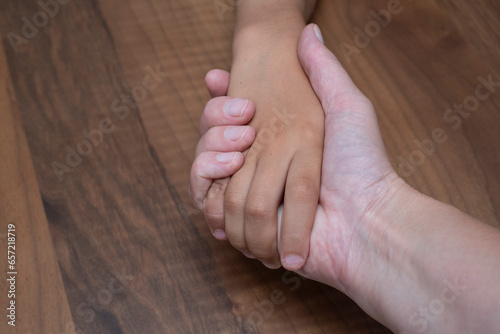 Mother is holding her 7-year-old son's hand