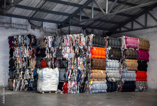 Heap of pressed colorful textile waste packed in bales in store-house