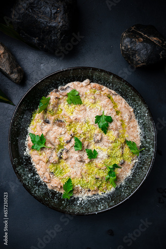 Italian food risotto with parmesan, champignon and greens.