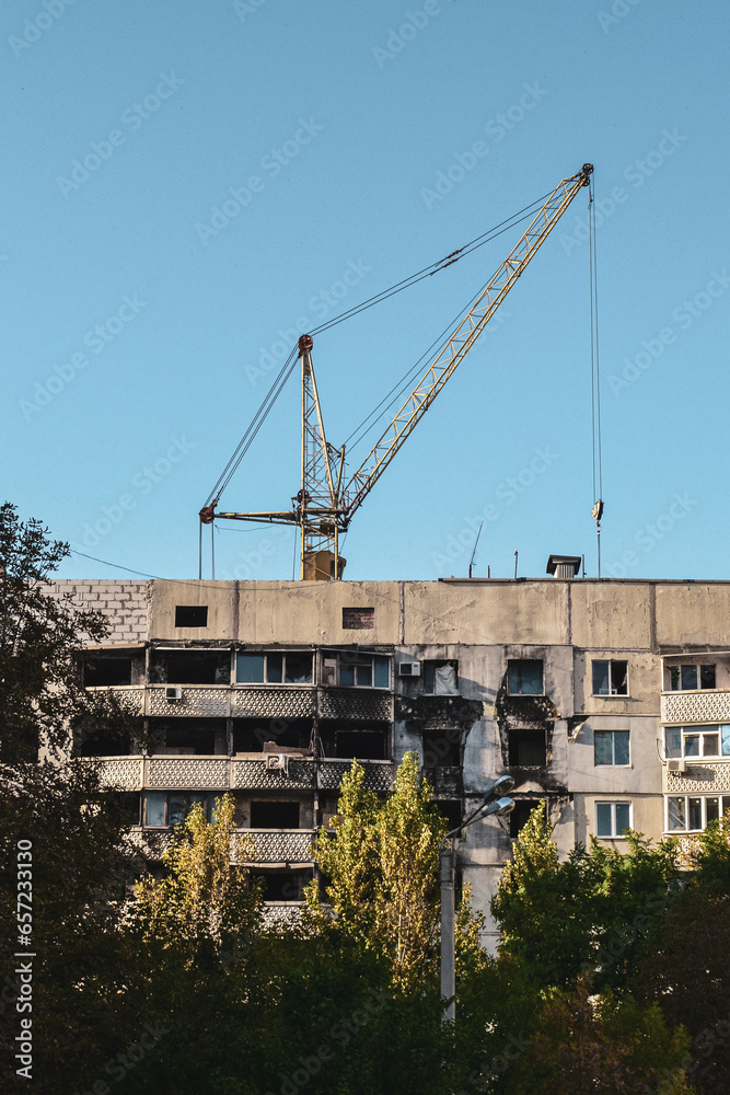 a construction crane is rebuilding a burnt house