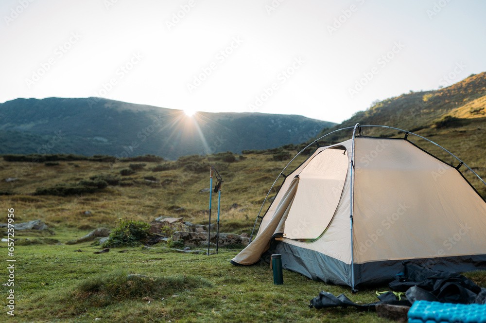 tent set in the mountains at sunset. The concept of active recreation 