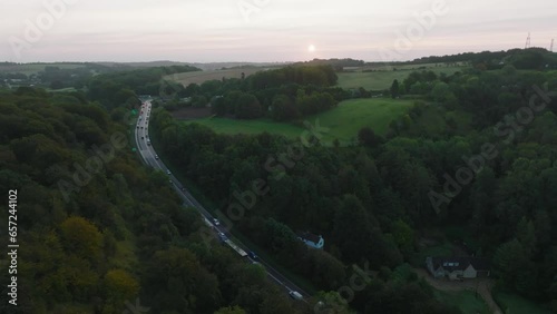 Aerial shot of a busy road through the British countryside at sunrise