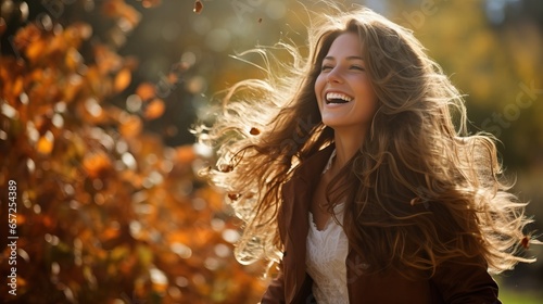Portrait of beautiful young woman with flying hair in autumn park.