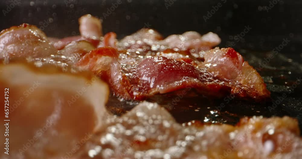 Frying halal beef bacon in pan side view macro shot slow motion. Classic breakfast spread, complete with bacon's irresistibly smoky and crispy goodness. Start the day with traditional breakfast. Fat Frying halal beef bacon in pan side view macro shot slow motion. Classic breakfast spread, complete with bacon's irresistibly smoky and crispy goodness. Start the day with traditional breakfast. Fat