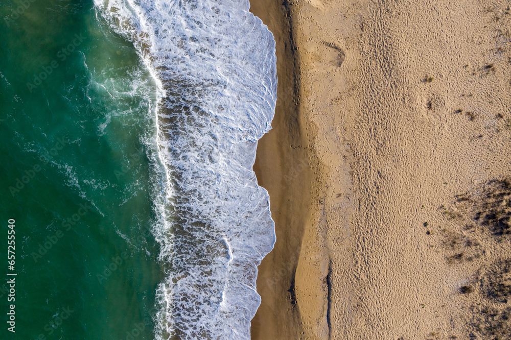 Aerial view of ocean waves washing a sandy shoreline Aerial view of ocean waves washing a sandy shoreline