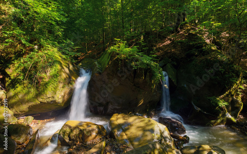 Fototapeta Naklejka Na Ścianę i Meble -  waterfall among the rocks in the forest. beautiful nature background in summertime. scenic natural park environment